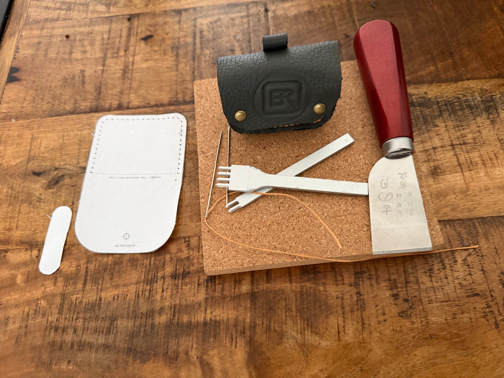 Leren AirPods hoesje naast het gereedschap waarmee het met de hand is gemaakt